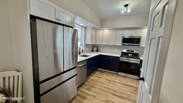 kitchen featuring white cabinetry, appliances with stainless steel finishes, sink, and backsplash