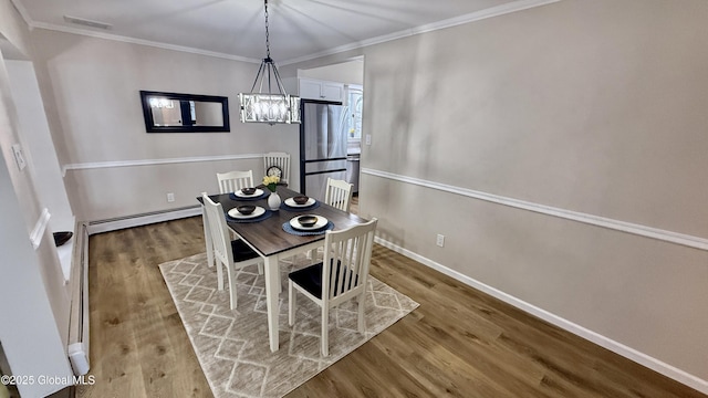 dining room with crown molding, light wood-type flooring, and baseboard heating