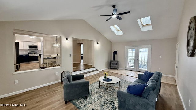 living room featuring wood-type flooring, high vaulted ceiling, ceiling fan, and french doors