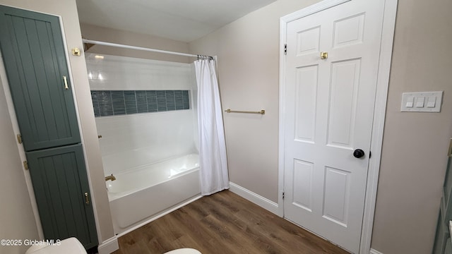 bathroom with shower / bath combination with curtain, wood-type flooring, and toilet