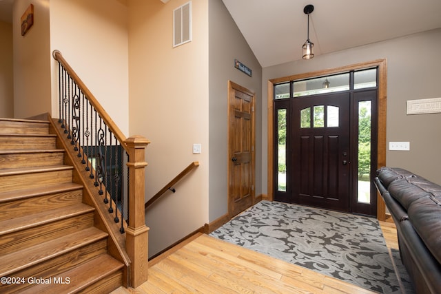 entryway with visible vents, baseboards, lofted ceiling, and wood finished floors