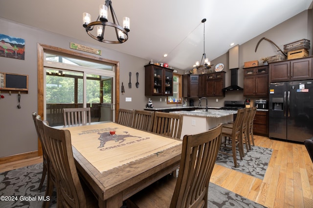 dining room featuring vaulted ceiling, a notable chandelier, recessed lighting, and light wood-type flooring