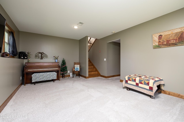 sitting room with visible vents, baseboards, carpet, and stairs