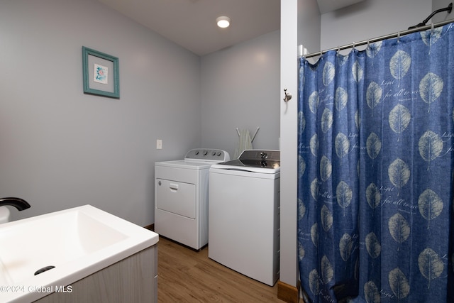 laundry area with laundry area, light wood-style flooring, recessed lighting, a sink, and washing machine and dryer