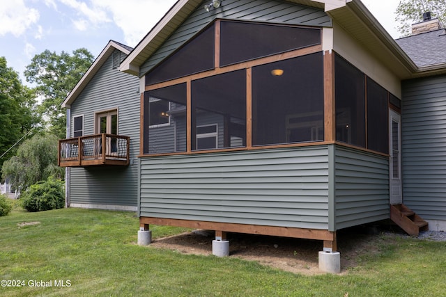 view of side of property with a yard and a sunroom