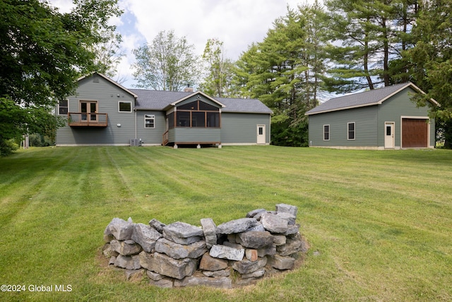 rear view of property with an outbuilding, a yard, a sunroom, and a chimney