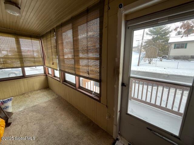 unfurnished sunroom featuring a wealth of natural light and wood ceiling