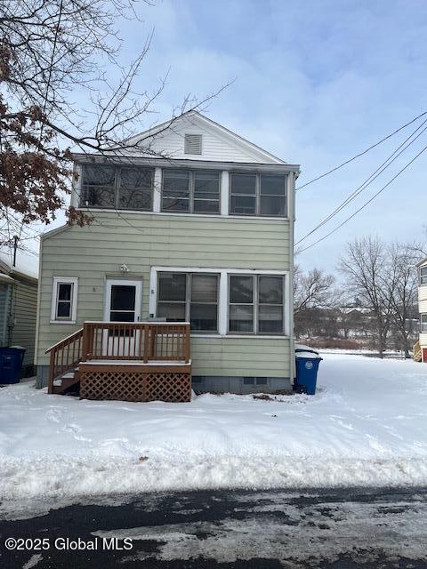 view of snow covered back of property