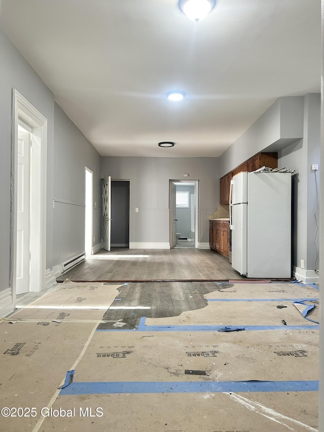 kitchen with baseboard heating and white fridge