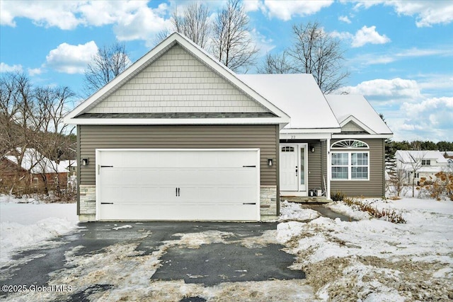 ranch-style house with a garage, stone siding, and driveway