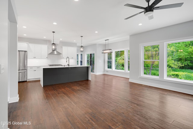 722 Swaggertown Rd, Glenville, NY 12302 - kitchen featuring freestanding refrigerator, wall chimney exhaust hood, light countertops, dark wood-type flooring, and white cabinetry