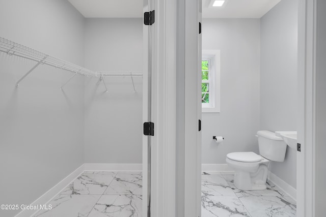 722 Swaggertown Rd, Glenville, NY 12302 - bathroom with marble look tile flooring, toilet, baseboards, and a spacious closet