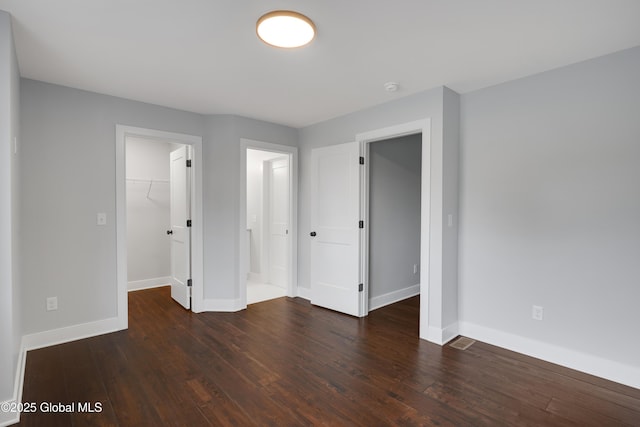 722 Swaggertown Rd, Glenville, NY 12302 - unfurnished bedroom featuring a walk in closet, baseboards, and hardwood / wood-style floors
