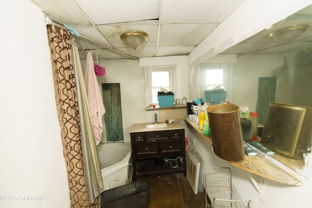 bathroom with shower / bath combo, a drop ceiling, and vanity