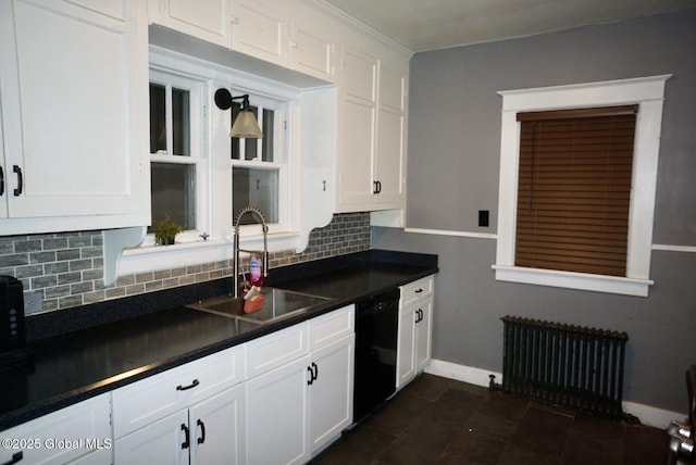 kitchen featuring sink, radiator heating unit, black dishwasher, white cabinets, and decorative backsplash