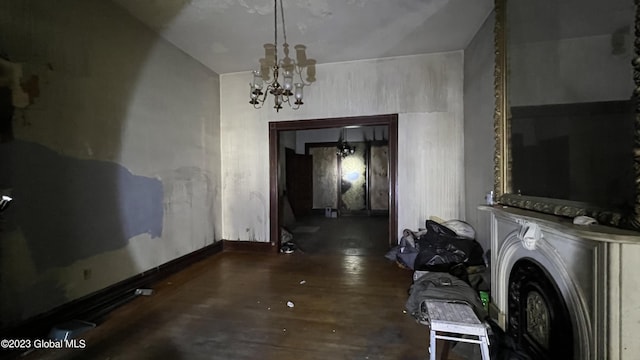 clothes washing area with dark hardwood / wood-style floors and a chandelier