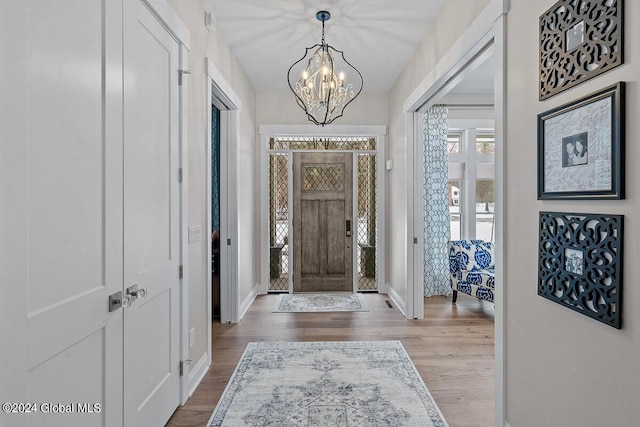 foyer with hardwood / wood-style flooring and an inviting chandelier