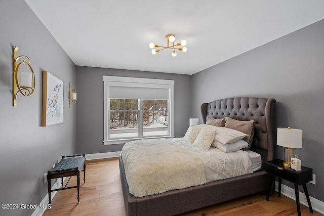 bedroom with hardwood / wood-style floors and a chandelier