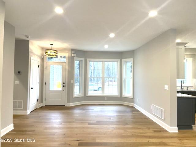 entryway with light wood finished floors, visible vents, and recessed lighting