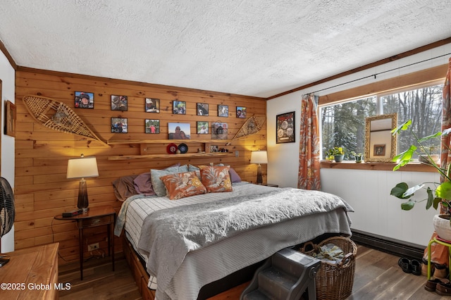 bedroom featuring wood-type flooring, wood walls, and a textured ceiling