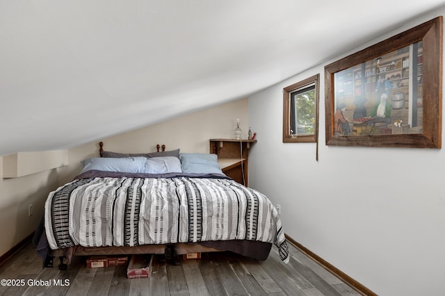 bedroom featuring baseboards, vaulted ceiling, and hardwood / wood-style flooring