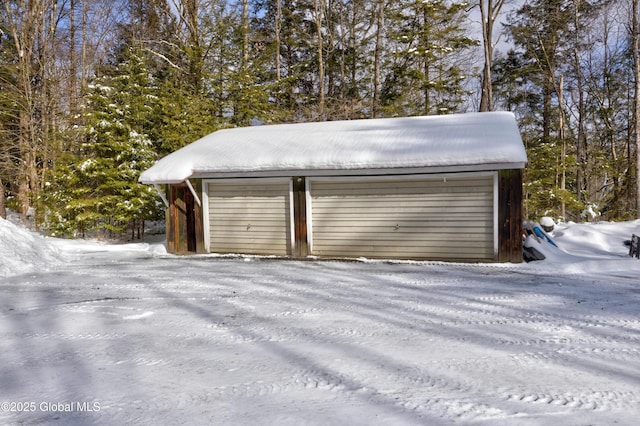 snow covered garage featuring a garage