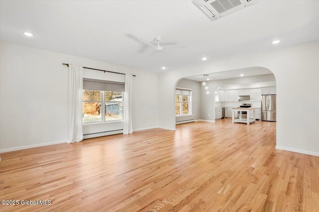 unfurnished living room featuring arched walkways, visible vents, light wood-style flooring, and baseboard heating