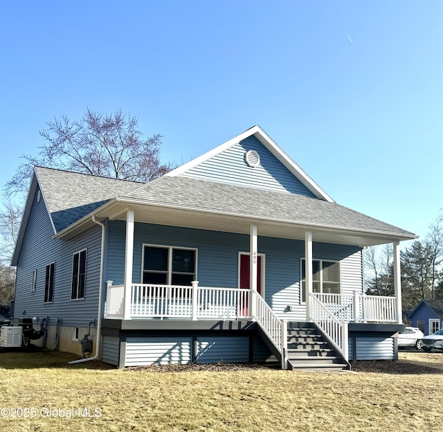 view of front of house with a porch, a front yard, and roof with shingles