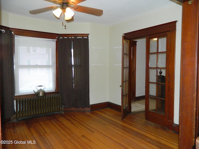 entryway with radiator, wood-type flooring, french doors, and ceiling fan