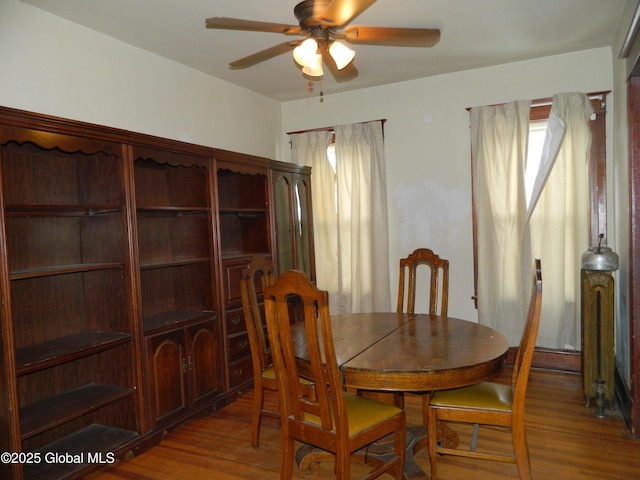 dining area featuring wood-type flooring and ceiling fan