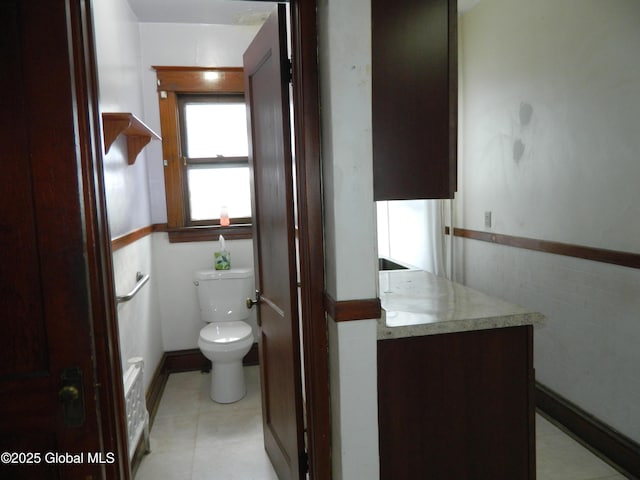 bathroom featuring vanity, tile walls, and toilet