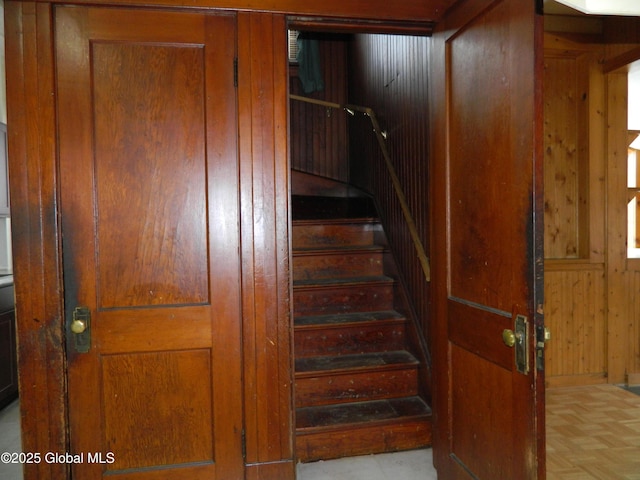 stairs with parquet flooring and wooden walls