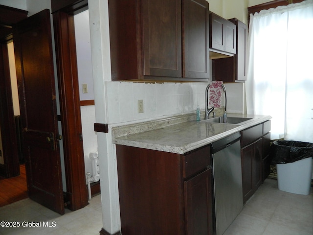 kitchen featuring dark brown cabinetry, sink, a wealth of natural light, and stainless steel dishwasher