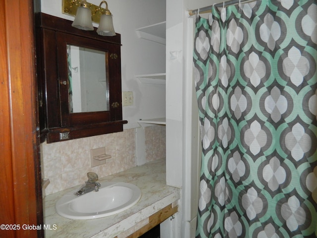 bathroom with tasteful backsplash, sink, and a shower with curtain