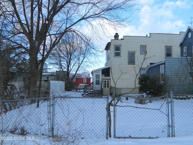 view of snow covered back of property