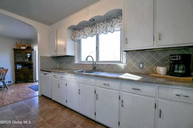 kitchen with visible vents, a sink, white dishwasher, white cabinetry, and dark tile patterned flooring