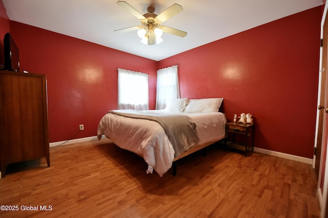 bedroom with ceiling fan, baseboards, and wood finished floors