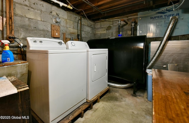 clothes washing area featuring laundry area, washer and dryer, and heating fuel