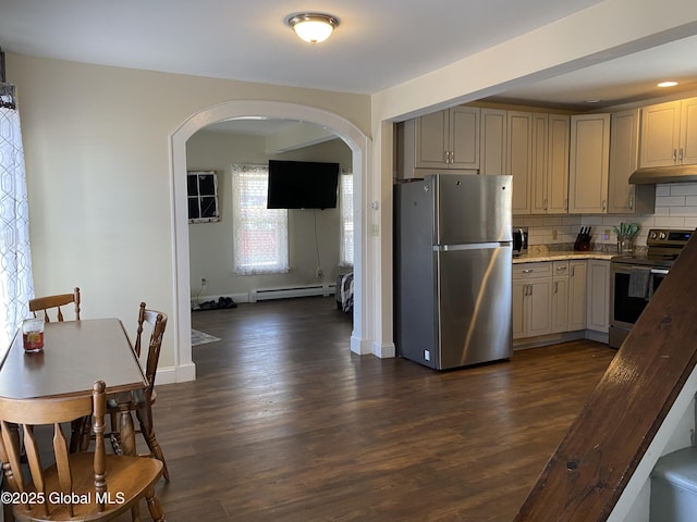 kitchen featuring arched walkways, a baseboard heating unit, stainless steel appliances, decorative backsplash, and dark wood-style floors