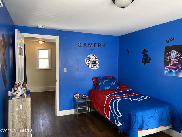 bedroom with baseboards and wood finished floors