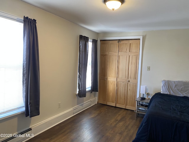 bedroom featuring dark wood-style floors, a baseboard radiator, multiple windows, and baseboards