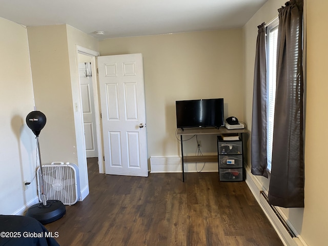 interior space featuring baseboards, baseboard heating, and wood finished floors