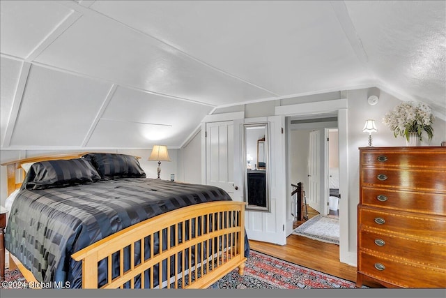 bedroom with hardwood / wood-style flooring and lofted ceiling