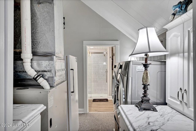 bedroom featuring heating unit, washer / dryer, and vaulted ceiling