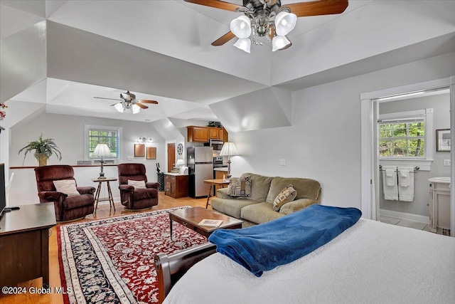 living room featuring ceiling fan, vaulted ceiling, and a wealth of natural light