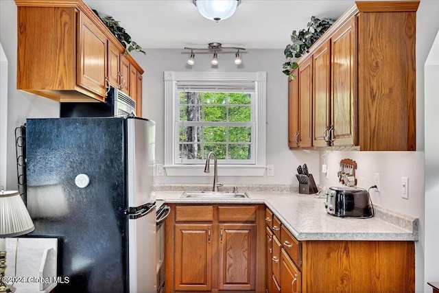 kitchen with sink, stainless steel fridge, and range