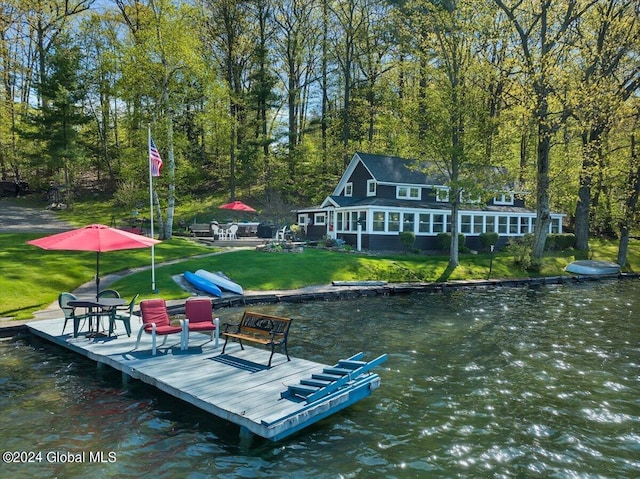 view of dock featuring a water view and a yard