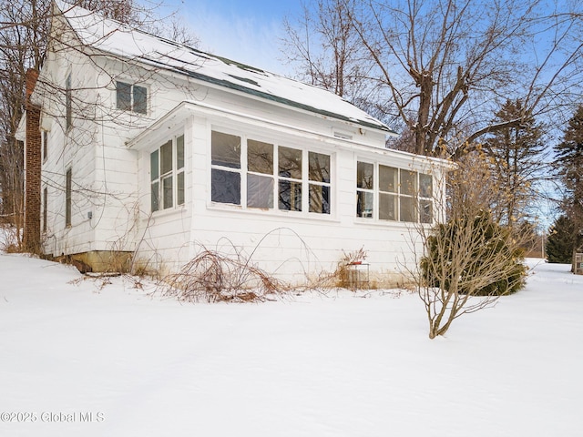 view of snow covered exterior featuring a sunroom