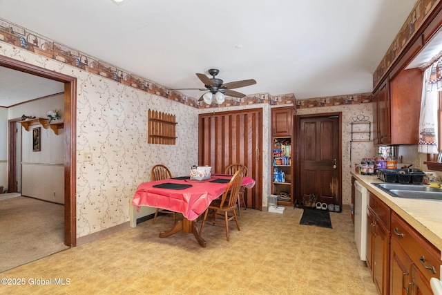 dining area featuring light floors, ceiling fan, baseboards, and wallpapered walls