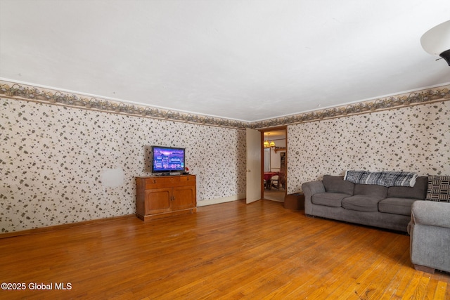 unfurnished living room featuring light wood-style floors, ornamental molding, baseboards, and wallpapered walls